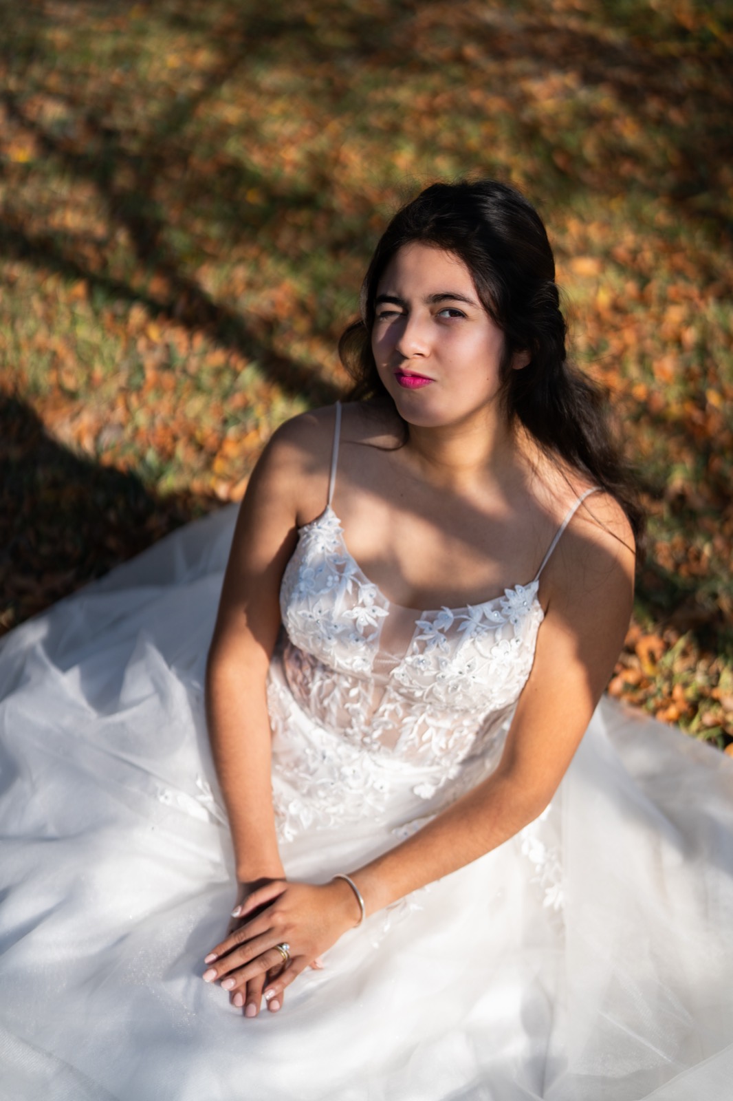 Novia sentada sobre hojas de otoño