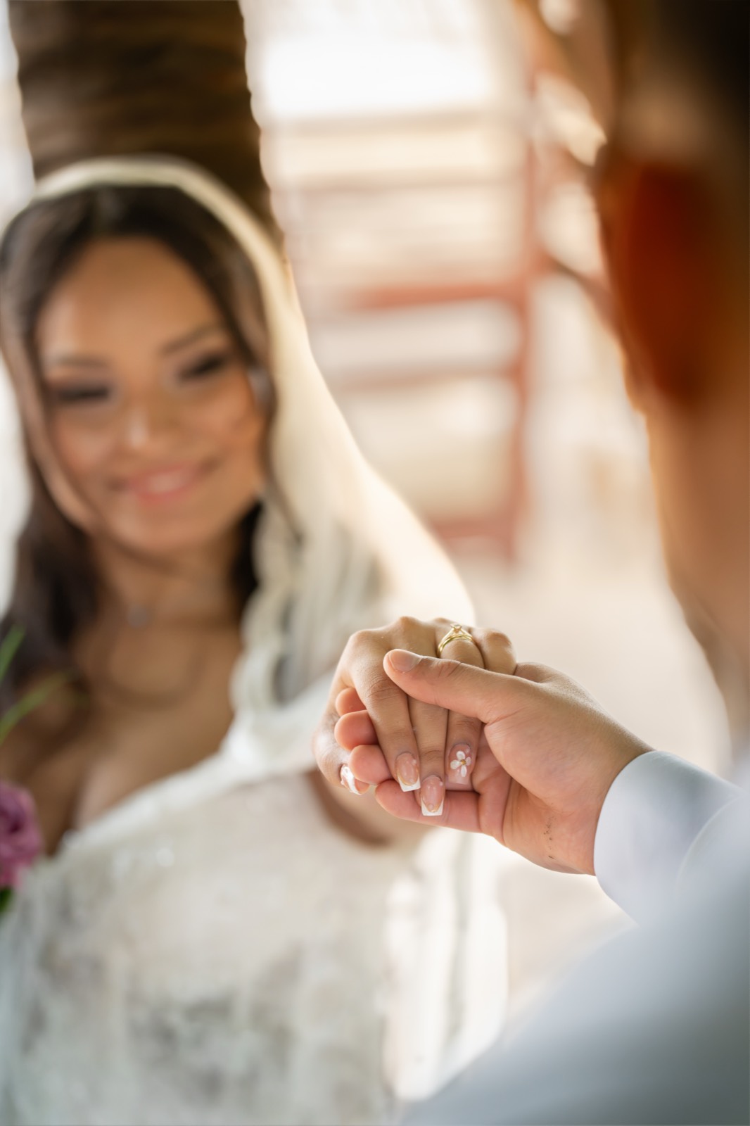Novio tomando la mano de la novia con su anillo